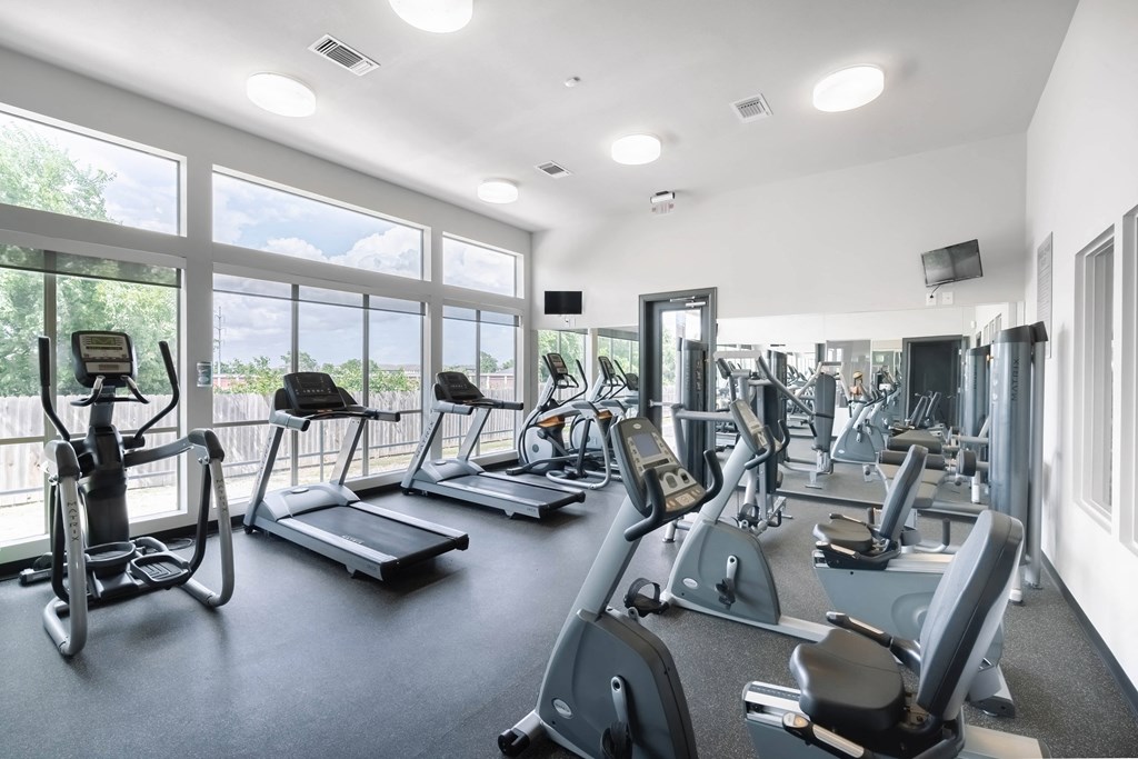 the gym with cardio equipment and windows at the belgard apartments