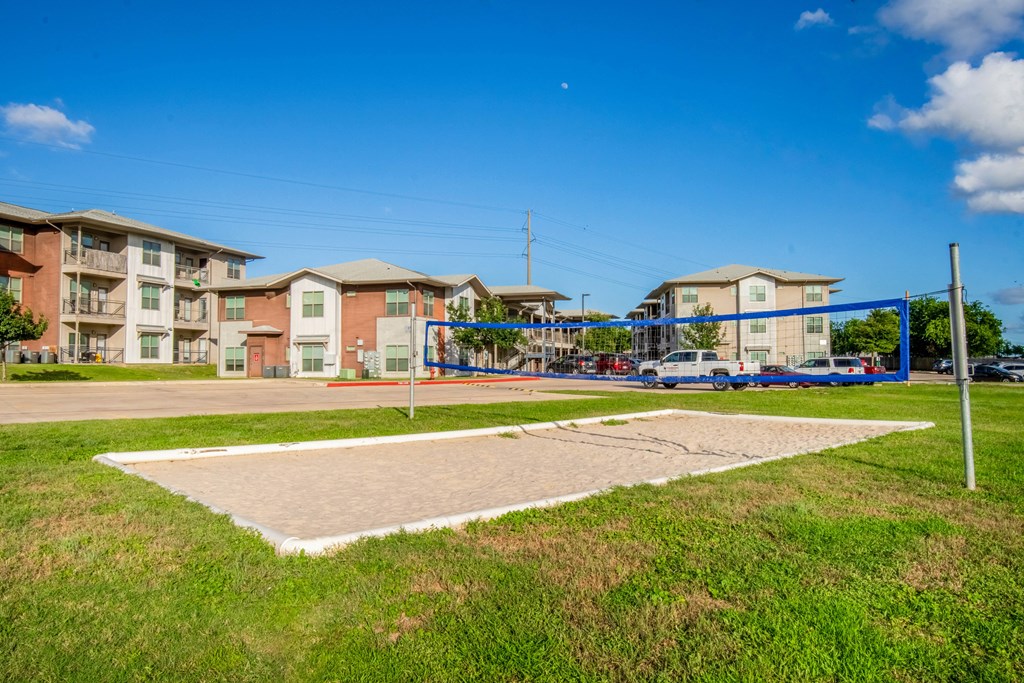 a basketball court with apartments in the background