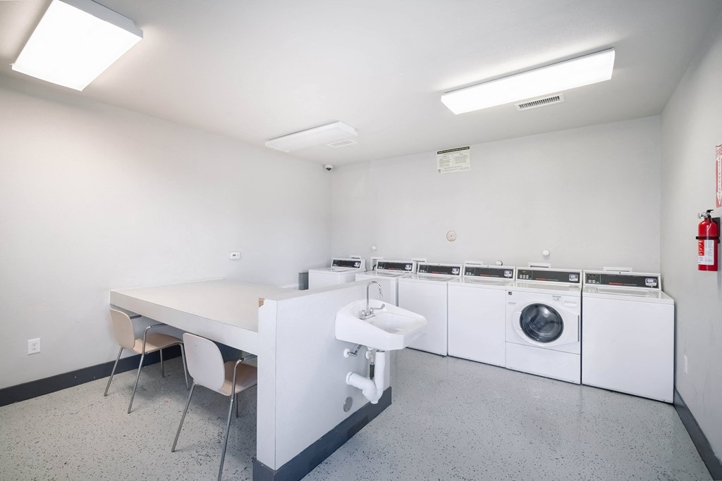 a laundry room with a table and chairs and a washing machine