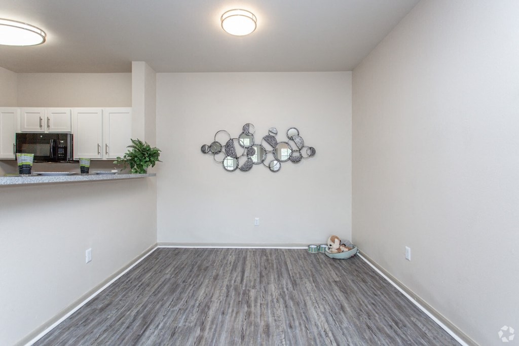 a spacious living room with a kitchen in the background
