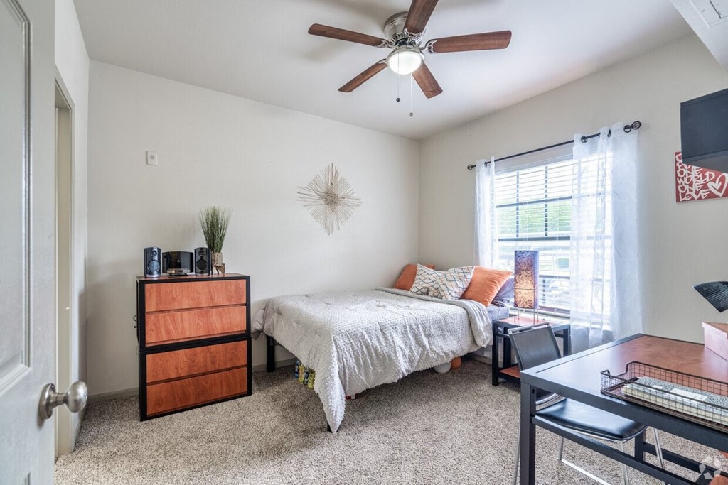 a bedroom with a bed and a ceiling fan