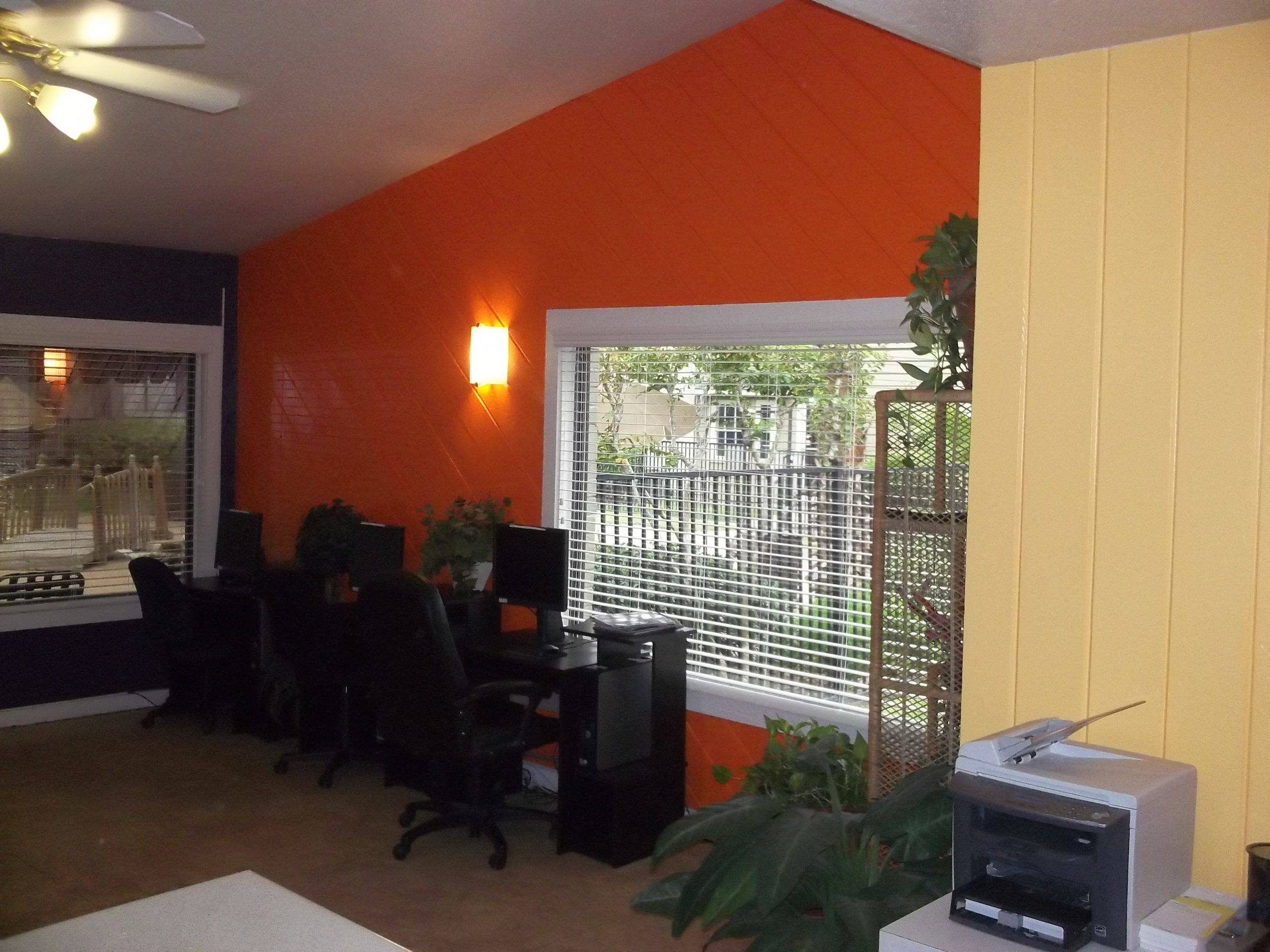 an office with a large window and a desk with chairs