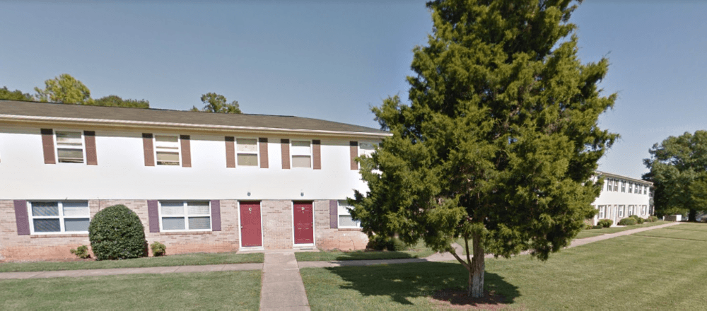 a white building with a tree in front of it