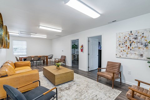 A living room with a large painting on the wall and a rug on the floor.