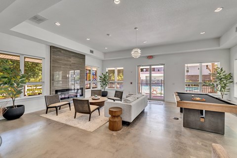 A spacious living room with a pool table and a view of the outdoors.