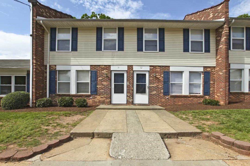 a house with a white door and a sidewalk in front of it