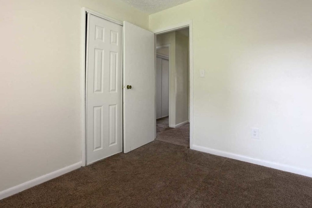 a room with a carpeted floor and a white door