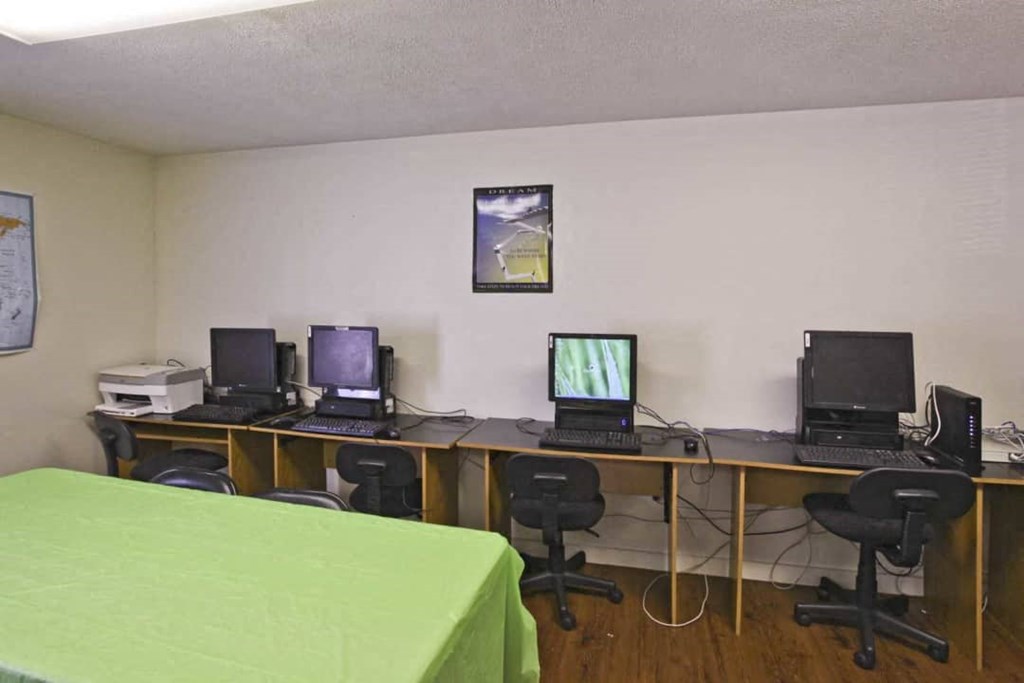 a room with three desks with computers on them