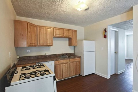 an empty kitchen with a stove and a refrigerator