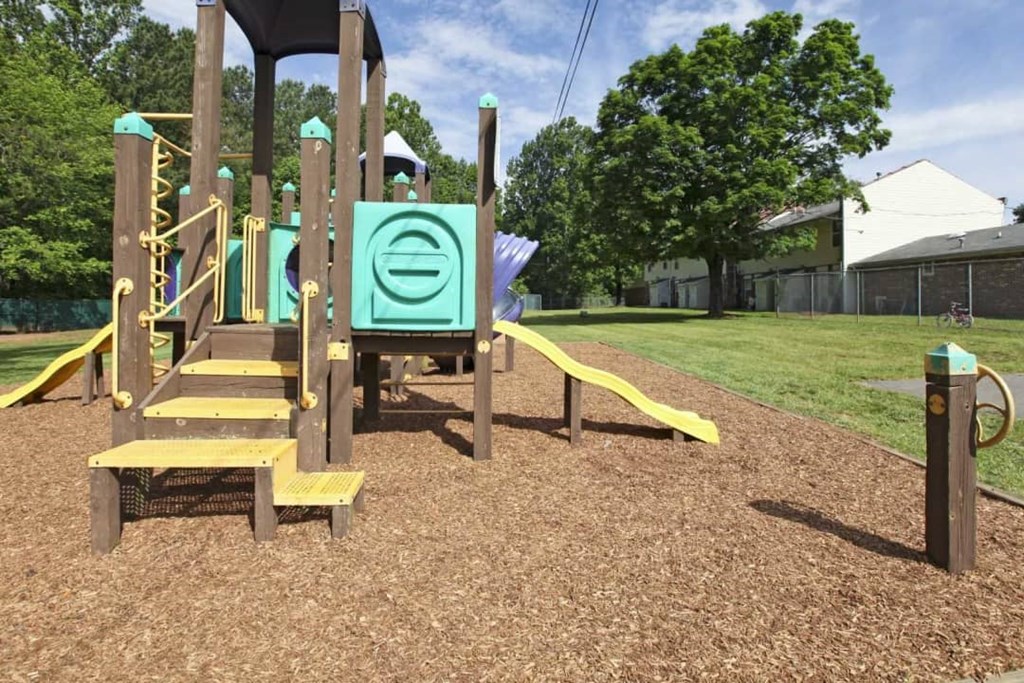 a playground at a park with a wooden playset