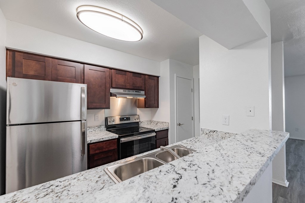 a kitchen with granite counter tops and stainless steel appliances