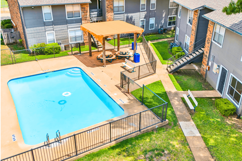 A small pool with a fence around it and a table and chairs in the middle of the pool.