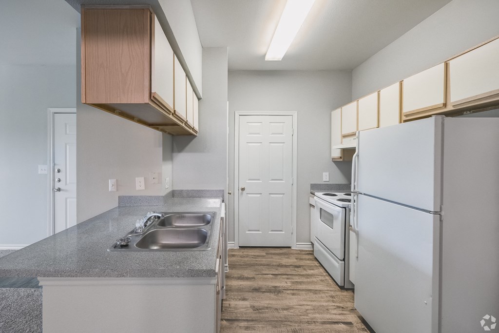 a kitchen with white appliances and a stainless steel refrigerator