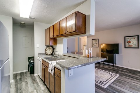 an open kitchen with a granite counter top and a sink