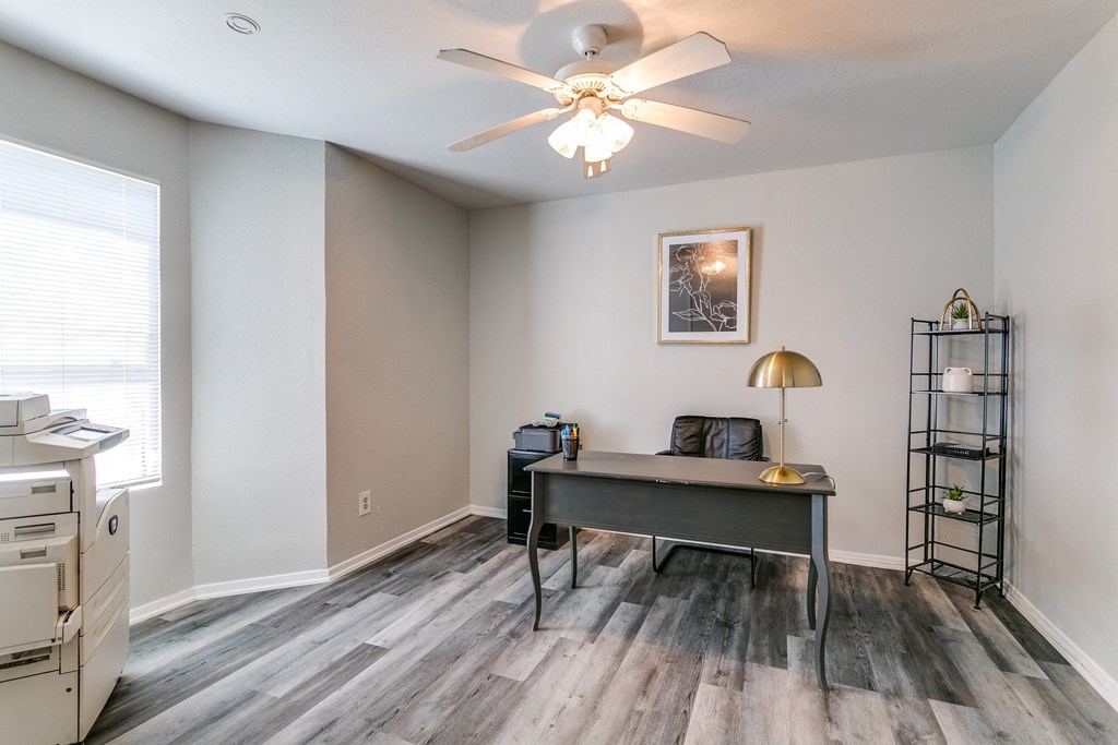 an office with a desk and a ceiling fan