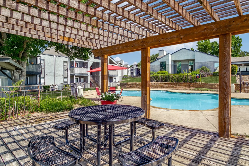 a patio with a table and chairs next to a pool