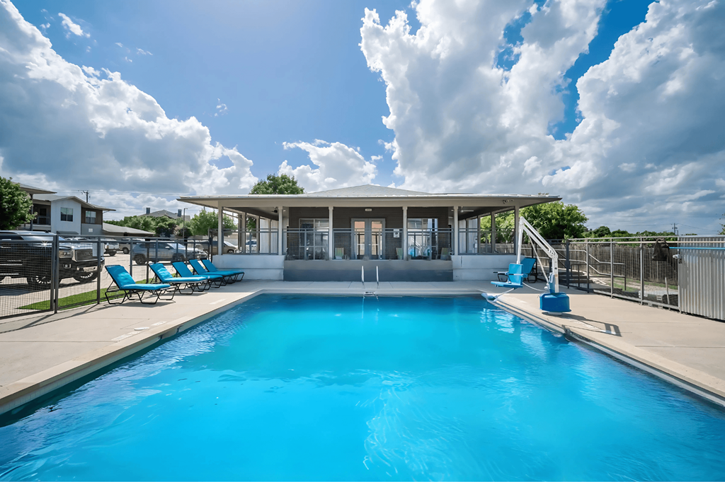 A large swimming pool with a building in the background.