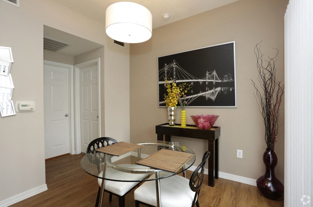 a dining room with a glass table and chairs