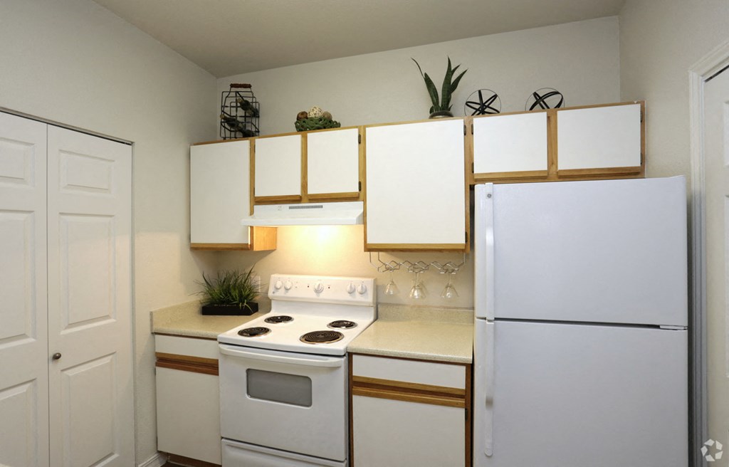 a kitchen with white appliances and a refrigerator