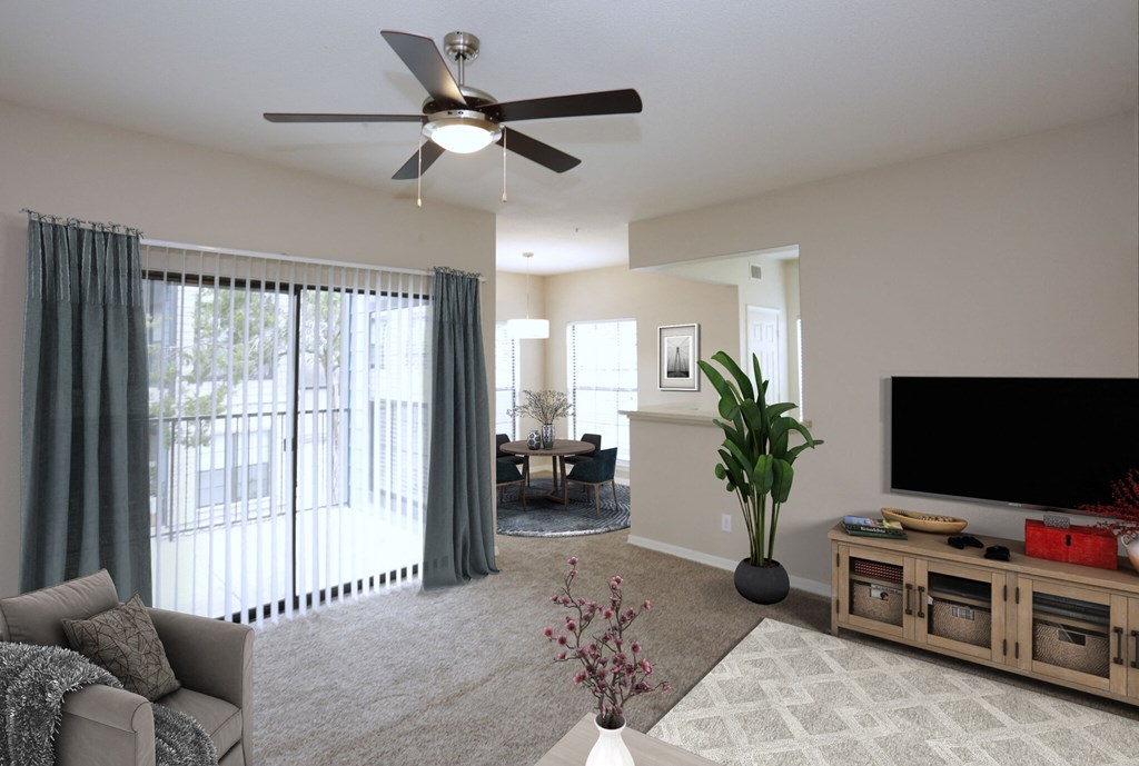 a living room with a ceiling fan and a large window