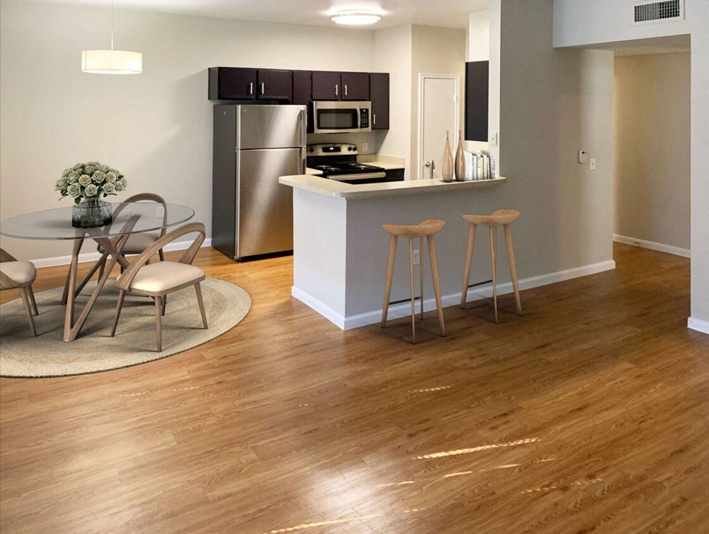 a living room with a kitchen and a table with chairs