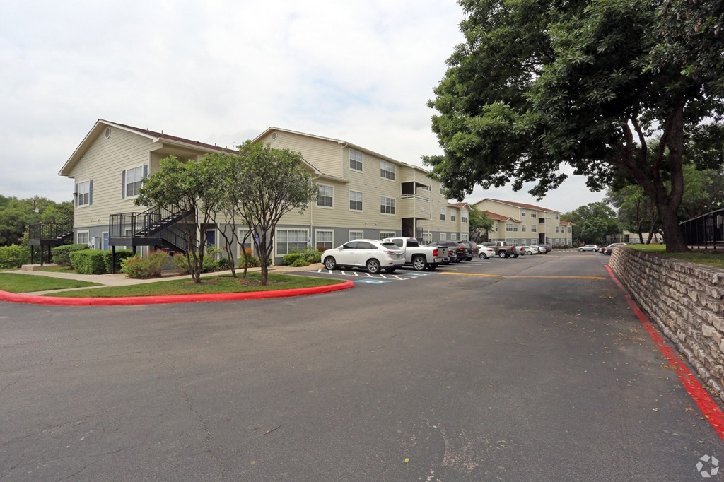 a city street with cars parked in front of apartment buildings