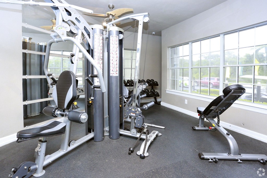 a home gym with exercise equipment and windows