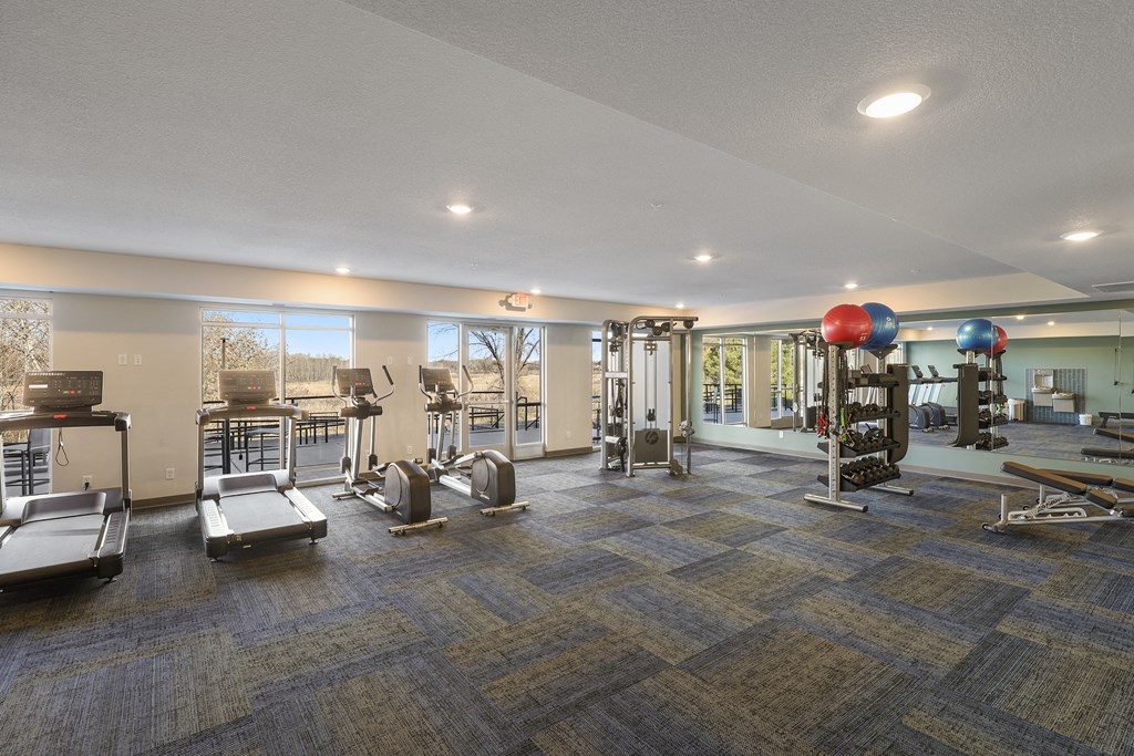 Fitness center with exercise equipment and windows
