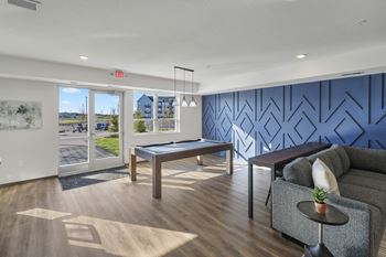a living room with a pool table and a blue accent wall