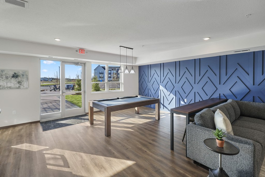 a clubroom with a pool table and a blue accent wall