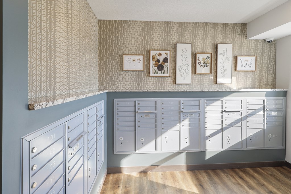 a mailroom with many cabinets and a wall with framed pictures