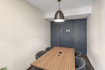 a conference room with a wooden table and a blue accent wall