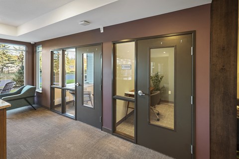 a conference room with glass doors and a table and chairs