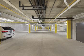 the inside of a parking garage with cars and yellow pillars
