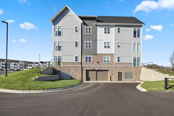 an image of an apartment building with a road in front of it
