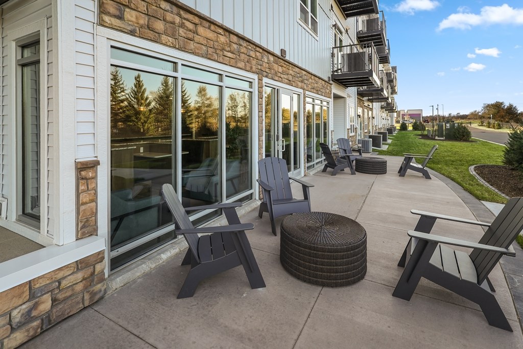 a patio with chairs and tables outside of a building