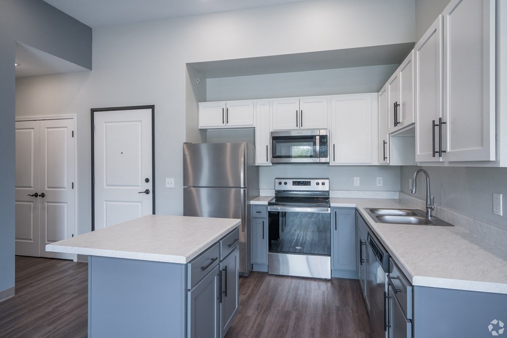 a kitchen with white cabinets and stainless steel appliances