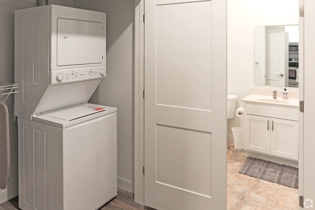 A white microwave oven is on top of a white dishwasher in a kitchen.