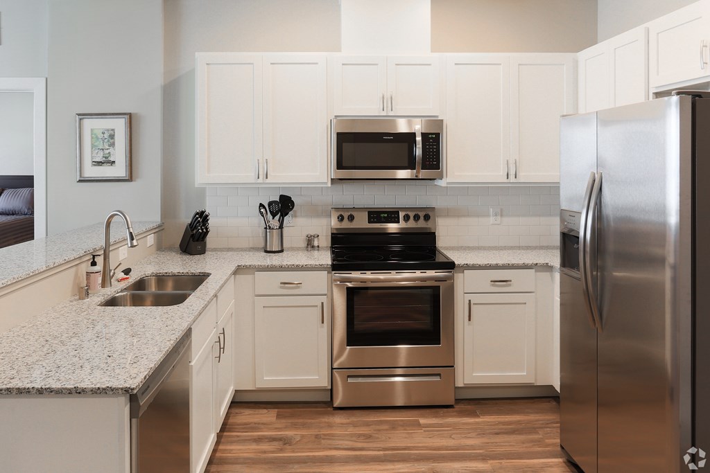 A modern kitchen with stainless steel appliances and white cabinets.