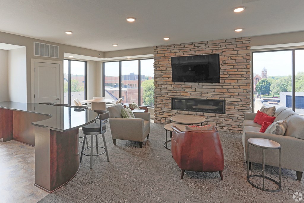 A living room with a stone fireplace and a television above it.