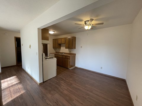 A kitchen area with a refrigerator, cabinets, and a ceiling fan.