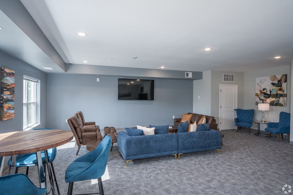 a living room with a blue couch and chairs and a table