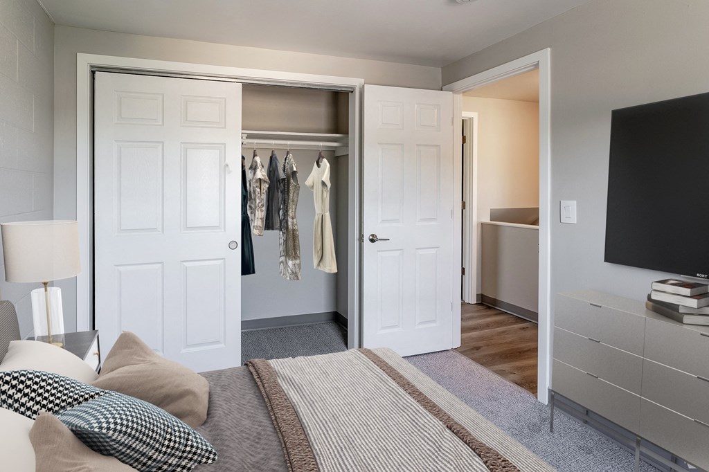 a bedroom with a bed and a closet with a tv
