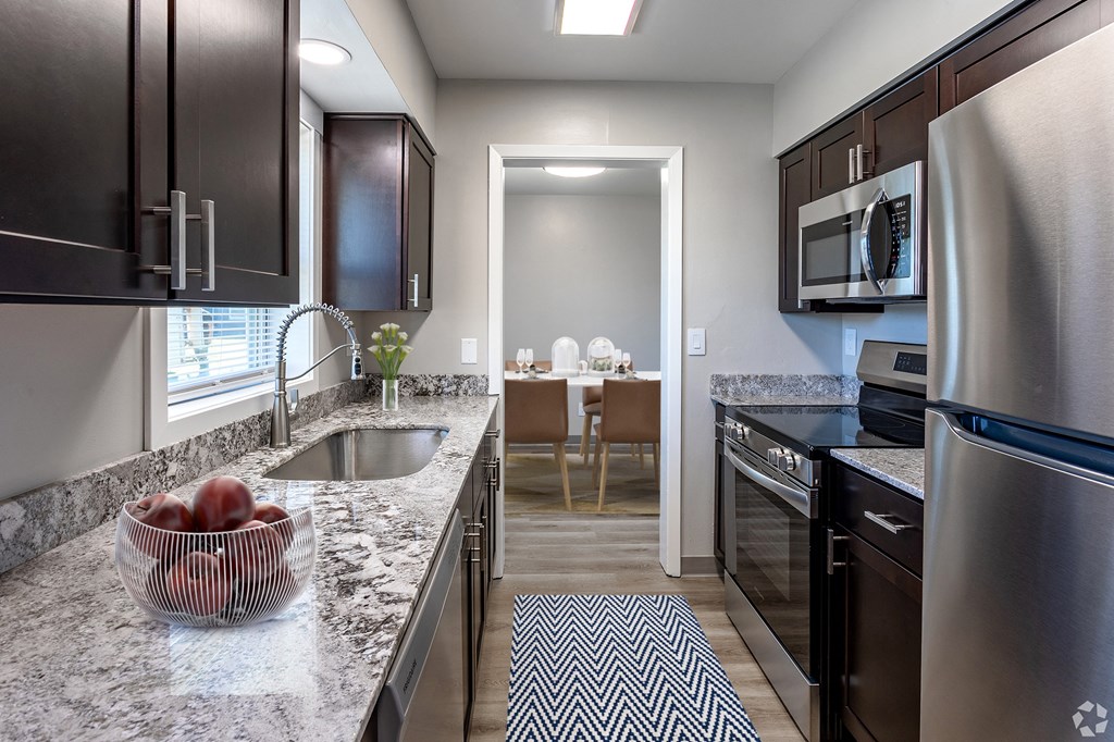 a kitchen with granite counter tops and stainless steel appliances