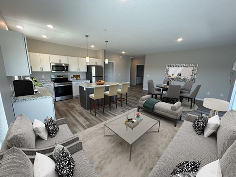 A modern living room with a grey sofa set and a glass coffee table.