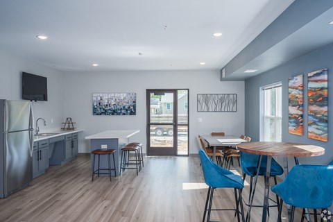 a dining room and kitchen with a table and chairs and a refrigerator and a door