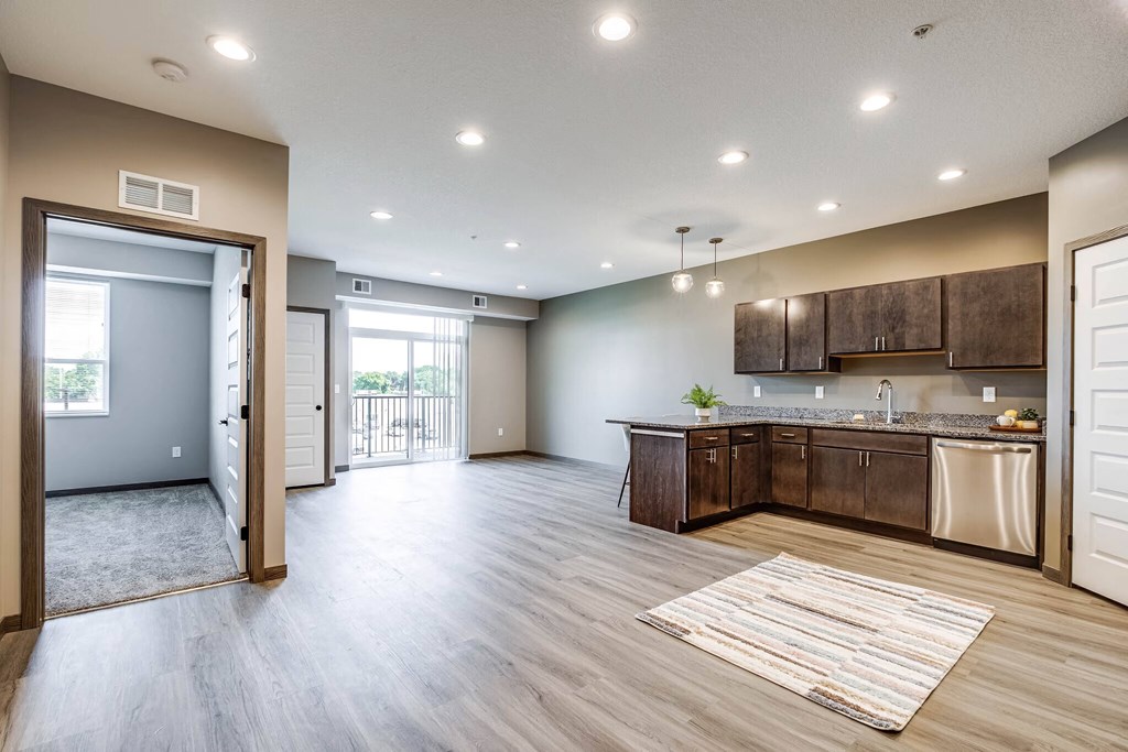 an open kitchen and living room with a door to a balcony