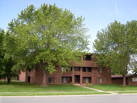 A large brick building with a tree in front of it.