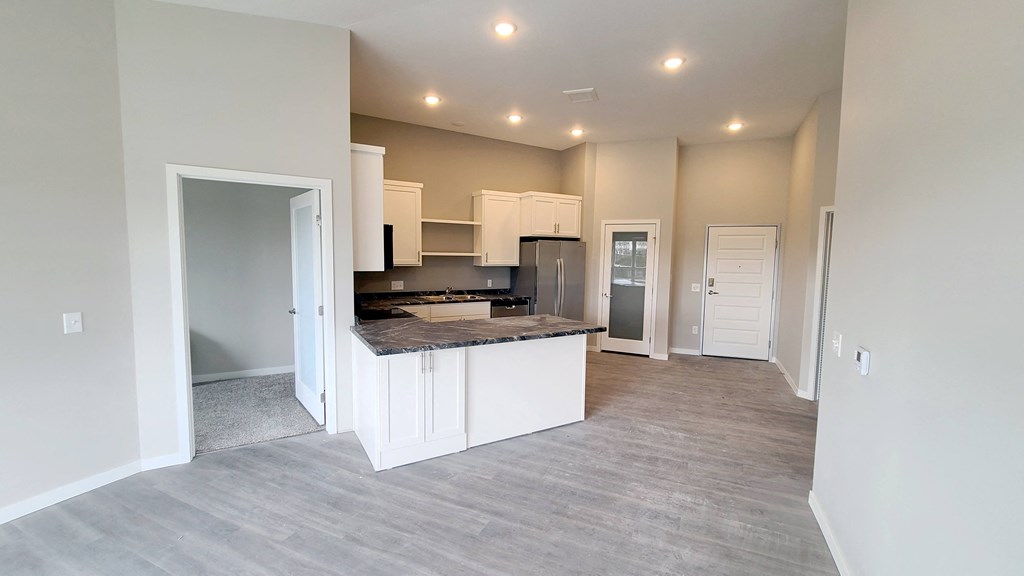 a kitchen with white cabinets and a counter top in a new home
