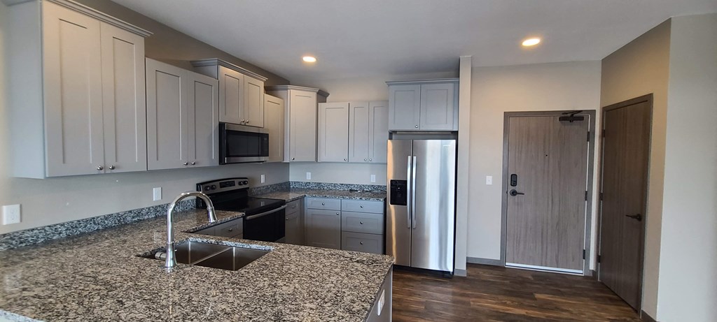 a kitchen with granite counter tops and white cabinets